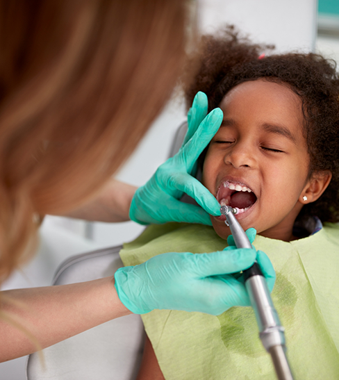 Little girl receiving dental checkup and cleaning from children's dentist in Fort Worth