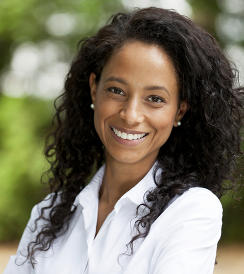 Woman with white shirt and curly hair smiling