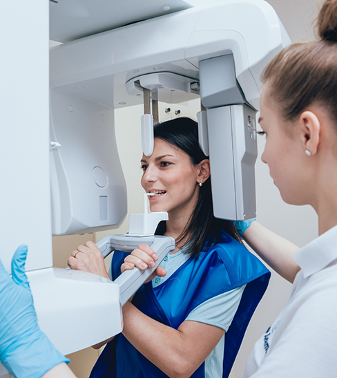 Female patient about to have teeth scanned with cone beam scanner