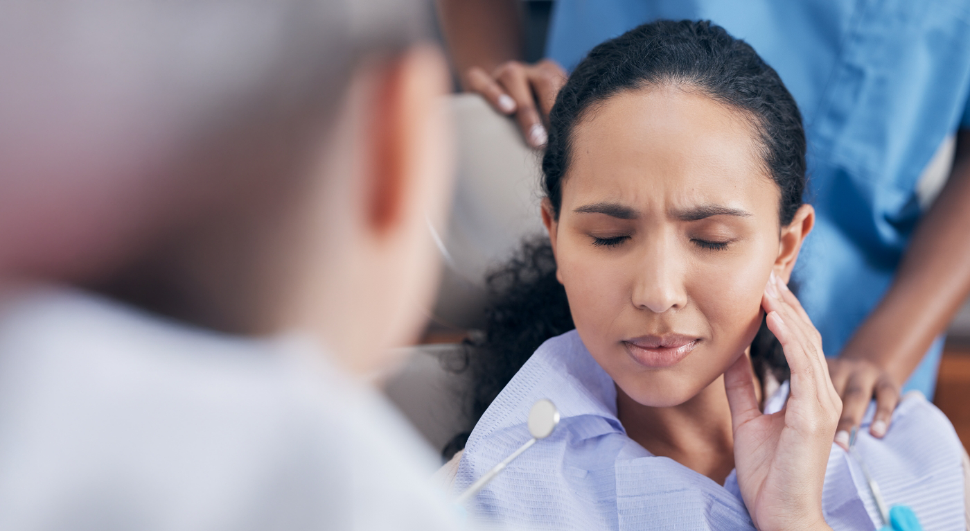 Close-up of woman with tooth pain visiting emergency dentist in Fort Worth