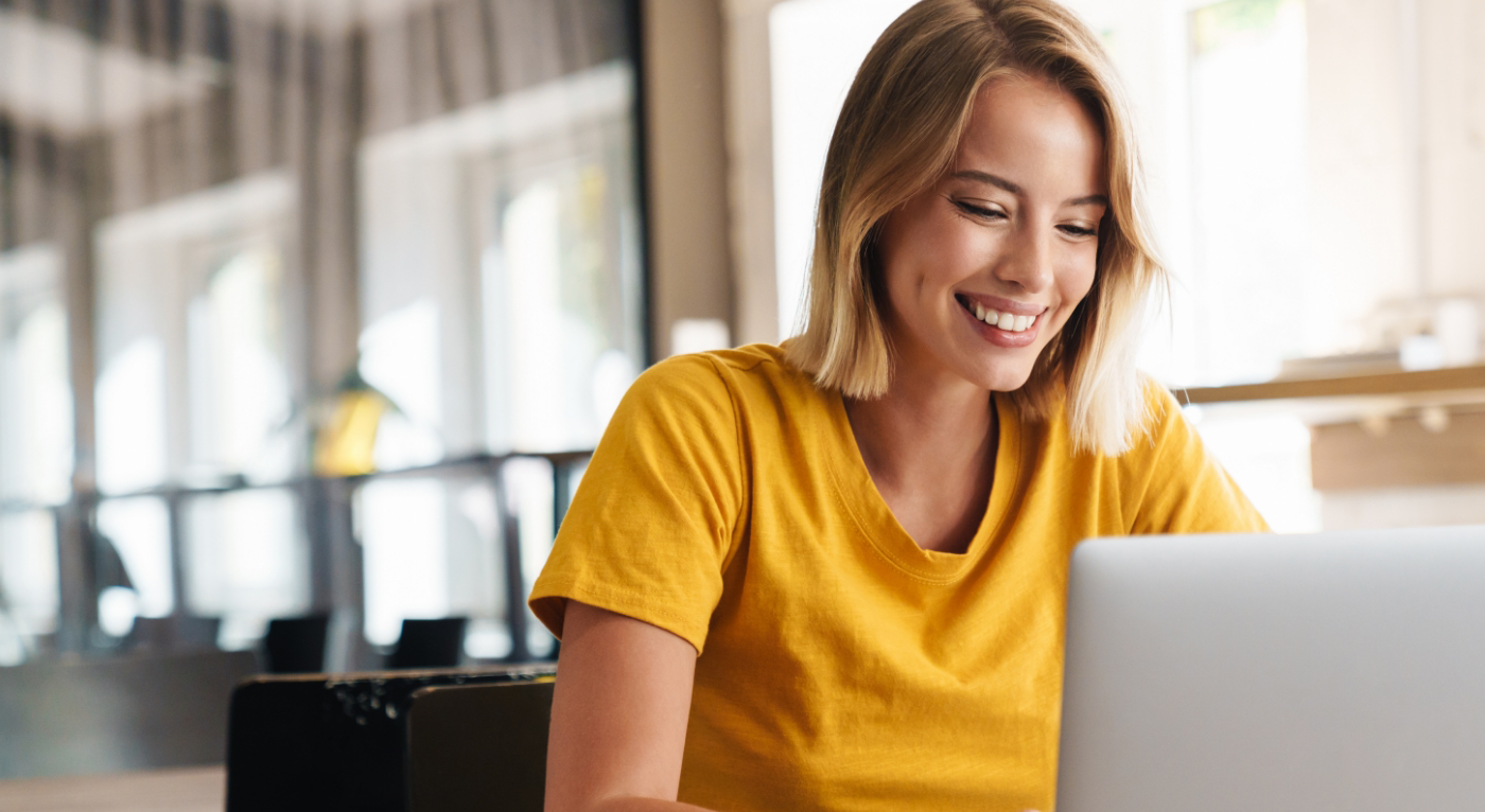 Woman in yellow shirt sitting at computer