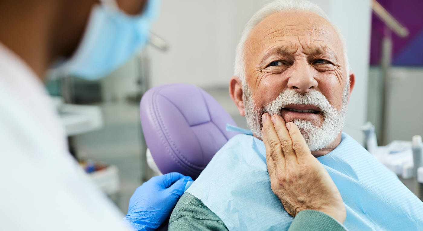 Older man in dental chair with tooth pain